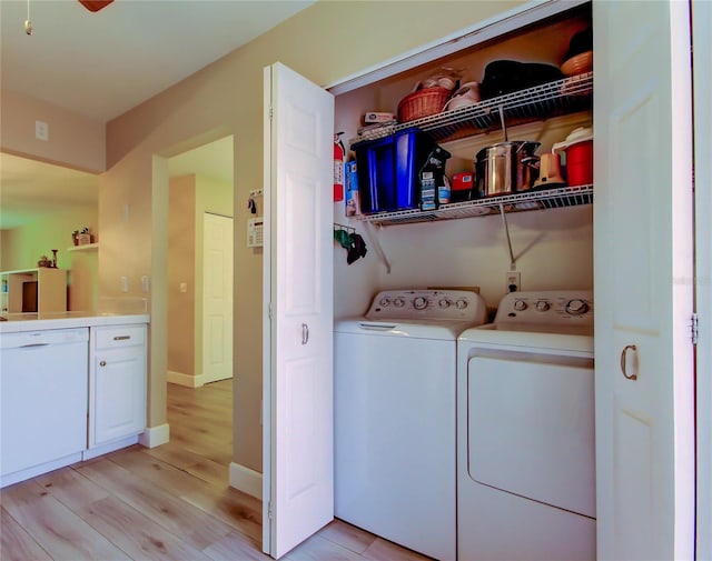 2913 Fig Ct, Palm Harbor, FL 34684 - laundry room with washing machine and dryer, light wood-type flooring, and baseboards