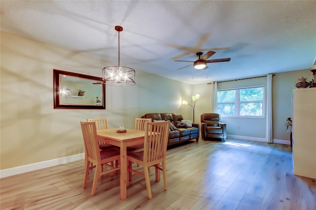 2913 Fig Ct, Palm Harbor, FL 34684 - dining area with ceiling fan, baseboards, light wood finished floors, a chandelier, and a textured ceiling