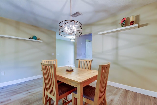 2913 Fig Ct, Palm Harbor, FL 34684 - dining area featuring a chandelier, light wood finished floors, and baseboards