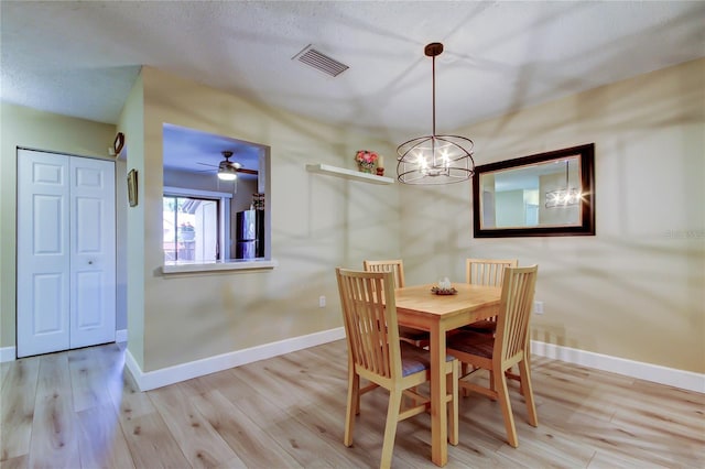 2913 Fig Ct, Palm Harbor, FL 34684 - dining area featuring wood finished floors, a chandelier, baseboards, a ceiling fan, and a textured ceiling
