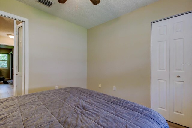 2913 Fig Ct, Palm Harbor, FL 34684 - bedroom with wood finished floors, ceiling fan, a textured ceiling, and a closet