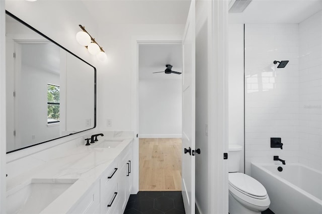 bathroom with toilet, double vanity, a ceiling fan, and bathing tub / shower combination