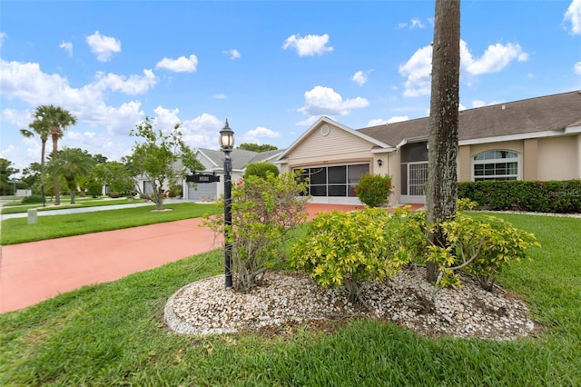 2015 W Del Webb Blvd, Sun City Center, FL 33573 - single story home featuring stucco siding, a front lawn, concrete driveway, and a shingled roof