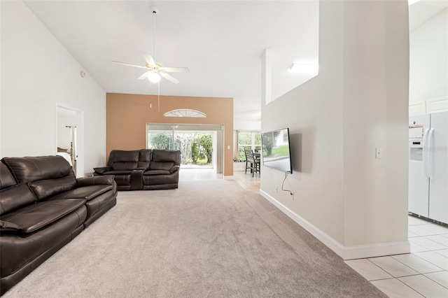 2015 W Del Webb Blvd, Sun City Center, FL 33573 - living room with high vaulted ceiling, ceiling fan, baseboards, light tile patterned floors, and light carpet