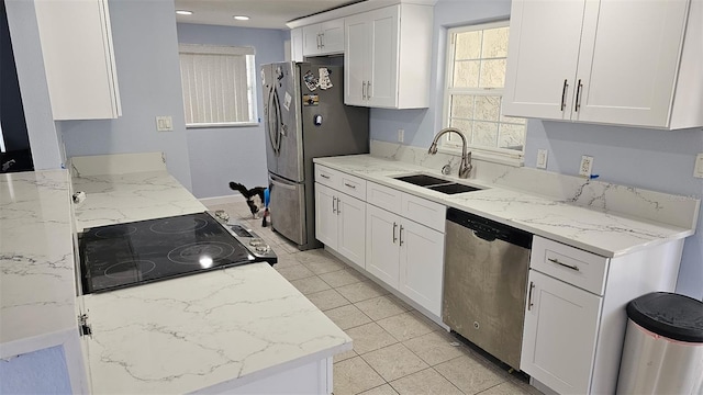 1500 Ohio Ave NE, Saint Petersburg, FL 33703 - kitchen with stainless steel appliances, a sink, white cabinetry, light stone counters, and baseboards