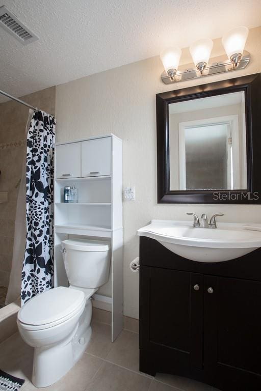 1500 Ohio Ave NE, Saint Petersburg, FL 33703 - full bath featuring tile patterned flooring, toilet, a tile shower, vanity, and a textured ceiling