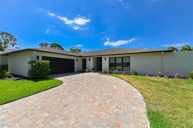 13916 Wellesford Way, Tampa, FL 33624 - view of front of house with stucco siding, a garage, a front yard, and decorative driveway