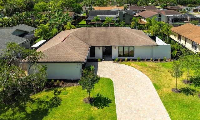 13916 Wellesford Way, Tampa, FL 33624 - view of front of property with a residential view, decorative driveway, roof with shingles, and a front yard