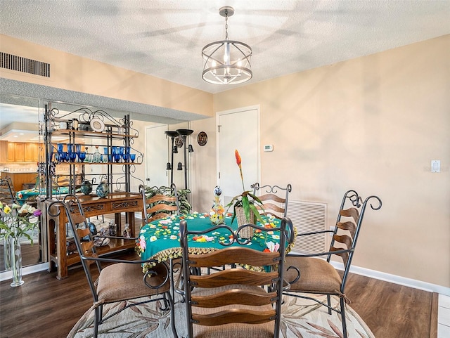 830 S Gulfview Blvd Unit 102, Clearwater Beach, FL 33767 - dining space featuring wood finished floors, a chandelier, a textured ceiling, and baseboards
