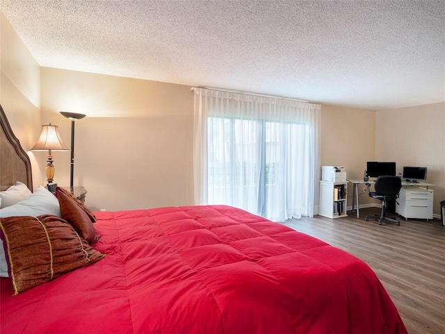830 S Gulfview Blvd Unit 102, Clearwater Beach, FL 33767 - bedroom featuring wood finished floors, a textured ceiling, and a desk