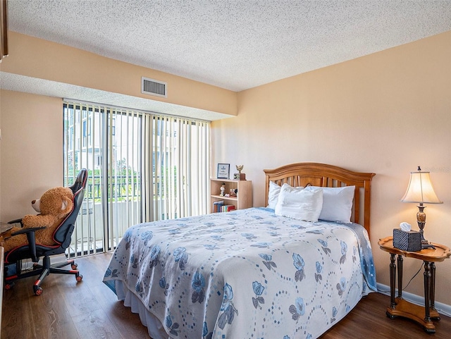 830 S Gulfview Blvd Unit 102, Clearwater Beach, FL 33767 - bedroom with wood finished floors, access to exterior, a textured ceiling, and baseboards