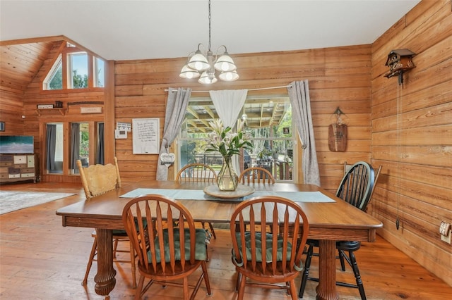5817 Myrtle Ln, Tampa, FL 33625 - dining area with wooden walls, a chandelier, wood-type flooring, vaulted ceiling, and plenty of natural light