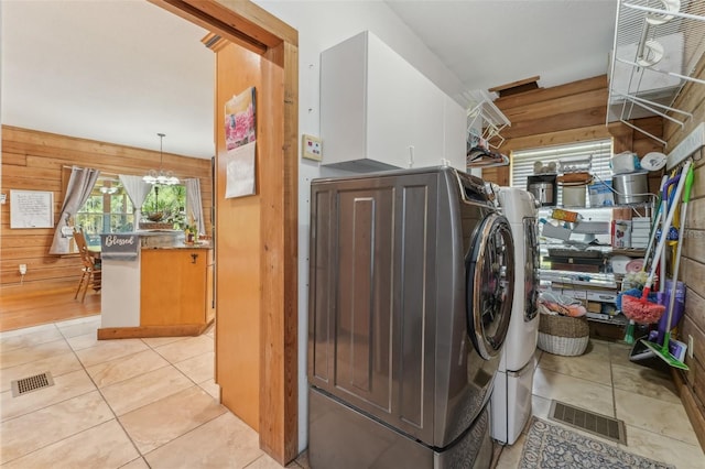 5817 Myrtle Ln, Tampa, FL 33625 - laundry room featuring wood walls, washing machine and dryer, and light tile patterned floors
