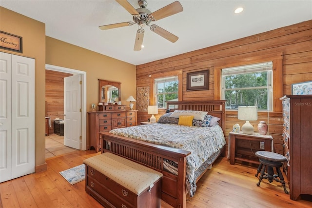 5817 Myrtle Ln, Tampa, FL 33625 - bedroom with multiple windows, light wood-style flooring, wooden walls, ceiling fan, and ensuite bathroom