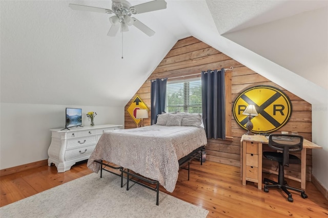 5817 Myrtle Ln, Tampa, FL 33625 - bedroom featuring wood walls, vaulted ceiling, hardwood / wood-style flooring, baseboards, and a ceiling fan