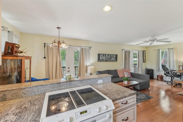 5817 Myrtle Ln, Tampa, FL 33625 - kitchen with white range with electric stovetop, a chandelier, open floor plan, light wood-style floors, and decorative light fixtures