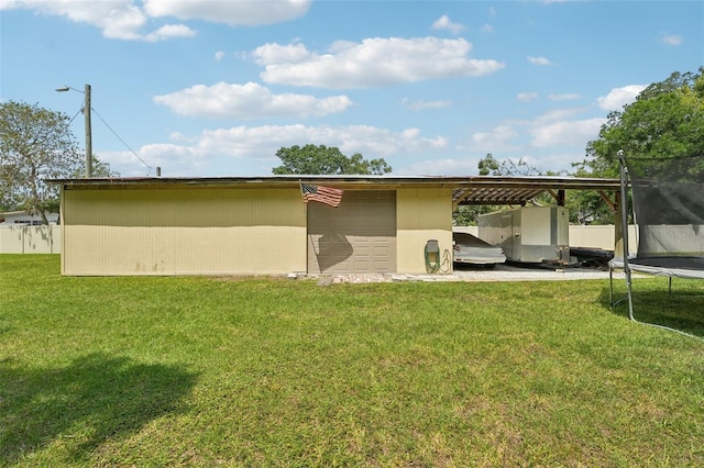 5817 Myrtle Ln, Tampa, FL 33625 - rear view of house featuring a trampoline, an outdoor structure, and a lawn