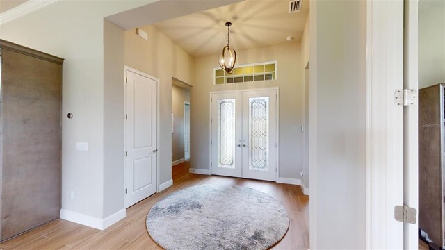 426 Bourganville Dr, Palm Coast, FL 32137 - foyer with french doors, light wood-style flooring, and baseboards