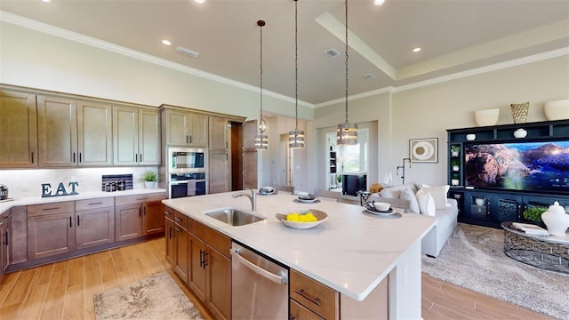 426 Bourganville Dr, Palm Coast, FL 32137 - kitchen with appliances with stainless steel finishes, a sink, light wood finished floors, a kitchen island with sink, and hanging light fixtures