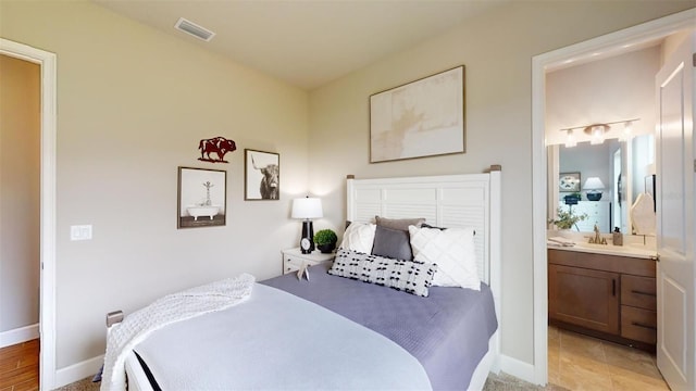 426 Bourganville Dr, Palm Coast, FL 32137 - bedroom with ensuite bath, baseboards, and a sink