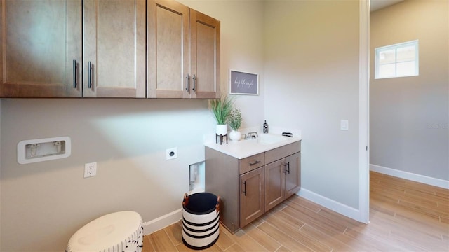 426 Bourganville Dr, Palm Coast, FL 32137 - clothes washing area featuring hookup for an electric dryer, hookup for a washing machine, light wood finished floors, baseboards, and cabinet space