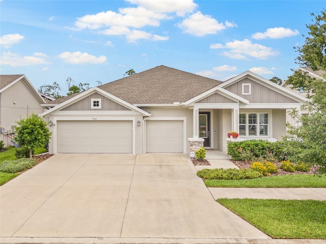 4166 Epic Cv, Land O Lakes, FL 34638 - view of front of house featuring an attached garage, roof with shingles, driveway, stucco siding, and board and batten siding