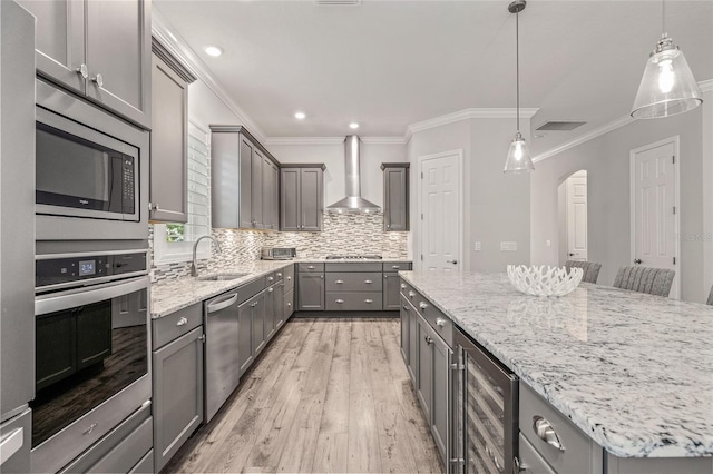 4166 Epic Cv, Land O Lakes, FL 34638 - kitchen featuring gray cabinetry, stainless steel appliances, a sink, beverage cooler, and wall chimney exhaust hood