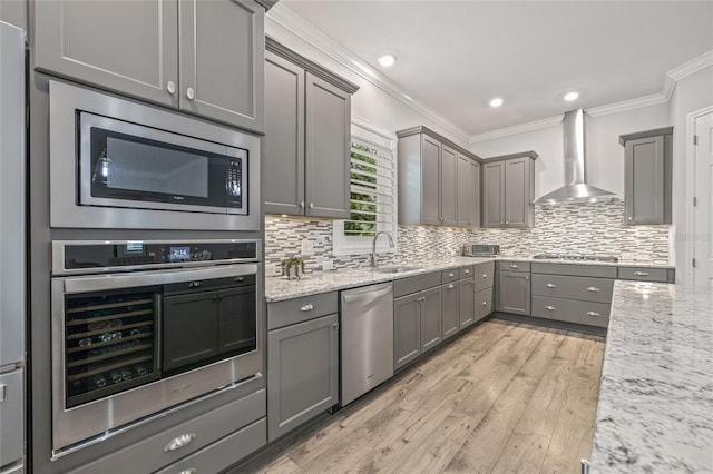 4166 Epic Cv, Land O Lakes, FL 34638 - kitchen with wall chimney exhaust hood, stainless steel appliances, gray cabinetry, a sink, and light wood-style floors
