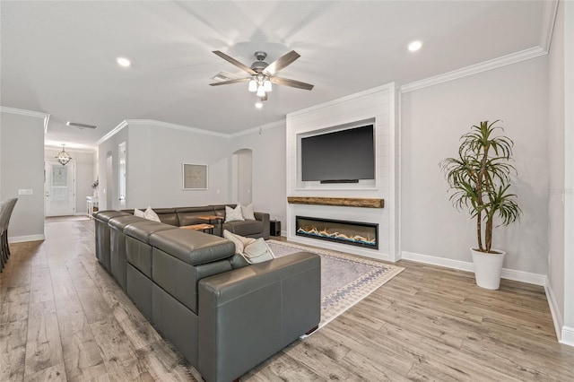 4166 Epic Cv, Land O Lakes, FL 34638 - living room featuring light wood-style flooring, ornamental molding, ceiling fan, baseboards, and arched walkways