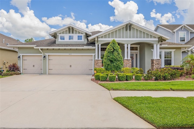 16712 Courtyard Loop, Land O Lakes, FL 34638 - craftsman house with stucco siding, concrete driveway, roof with shingles, stone siding, and an attached garage