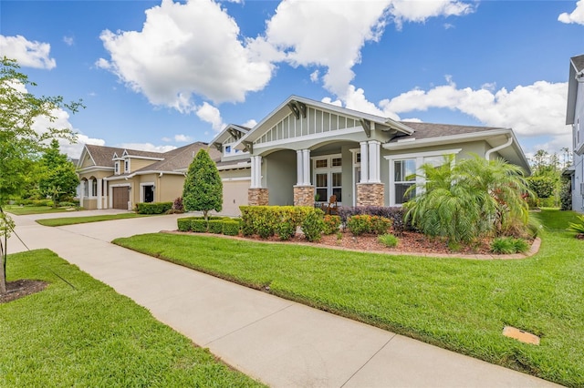 16712 Courtyard Loop, Land O Lakes, FL 34638 - craftsman-style home with driveway, stucco siding, a front yard, and stone siding