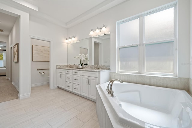 16712 Courtyard Loop, Land O Lakes, FL 34638 - ensuite bathroom featuring double vanity, a relaxing tiled tub, and toilet
