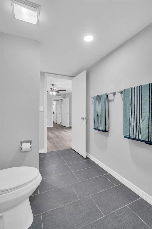 bathroom featuring baseboards, toilet, tile patterned floors, and ceiling fan