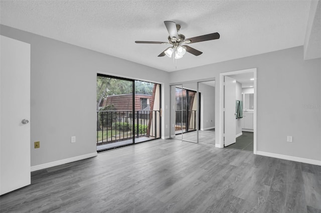 714 1st Ct, Palm Harbor, FL 34684 - unfurnished bedroom featuring access to exterior, a textured ceiling, wood finished floors, baseboards, and connected bathroom