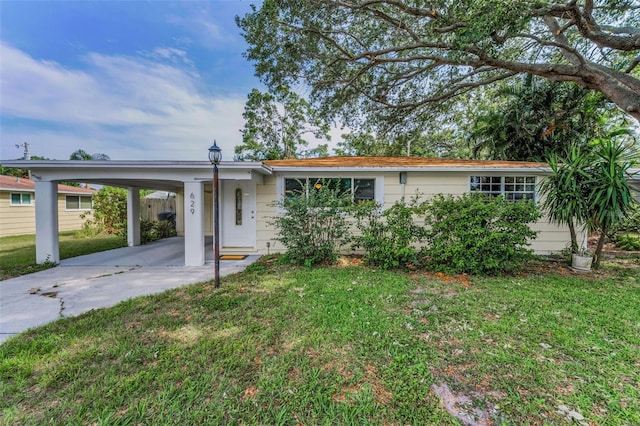 629 Lexington St, Dunedin, FL 34698 - ranch-style home with driveway, a carport, and a front yard