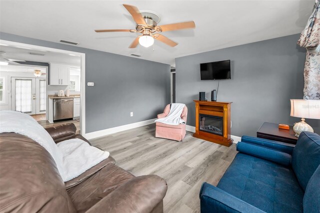 629 Lexington St, Dunedin, FL 34698 - living room with ceiling fan, light wood finished floors, and a glass covered fireplace