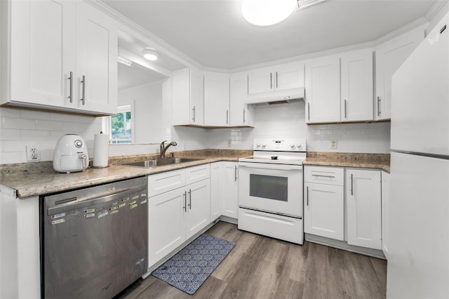 629 Lexington St, Dunedin, FL 34698 - kitchen featuring white appliances, under cabinet range hood, white cabinets, wood finished floors, and decorative backsplash