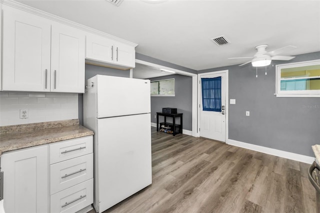 629 Lexington St, Dunedin, FL 34698 - kitchen with freestanding refrigerator, a ceiling fan, white cabinetry, and backsplash