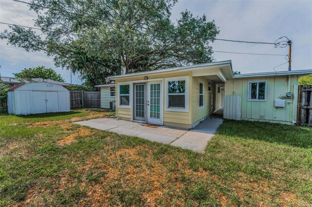 629 Lexington St, Dunedin, FL 34698 - rear view of property with a fenced backyard, french doors, a storage shed, board and batten siding, and a patio area