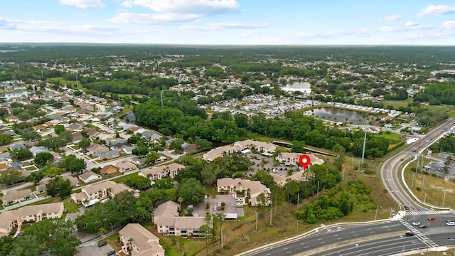 aerial view of property's location with a nearby body of water and nearby suburban area