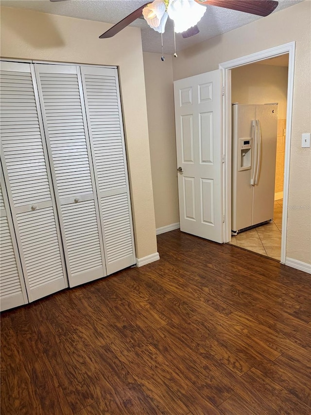 1020 85th Ave N Unit 223, Saint Petersburg, FL 33702 - unfurnished bedroom with white fridge with ice dispenser, a closet, wood finished floors, baseboards, and a ceiling fan