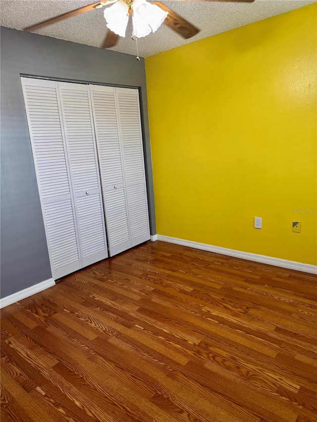1020 85th Ave N Unit 223, Saint Petersburg, FL 33702 - unfurnished bedroom featuring wood finished floors, baseboards, ceiling fan, a closet, and a textured ceiling