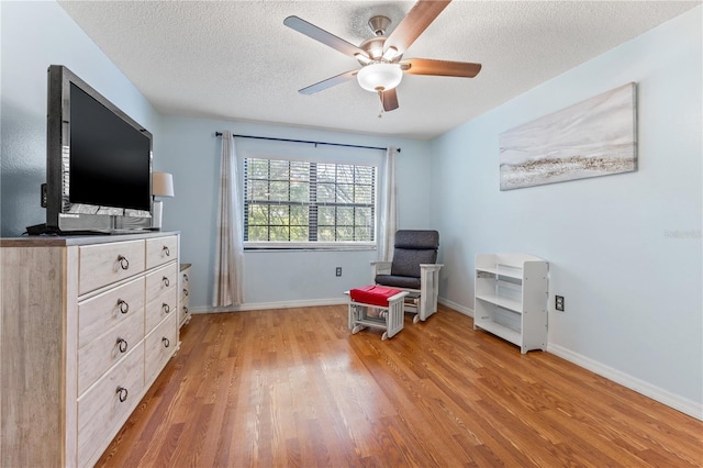1020 85th Ave N Unit 223, Saint Petersburg, FL 33702 - living area featuring light wood-style floors, a textured ceiling, a ceiling fan, and baseboards