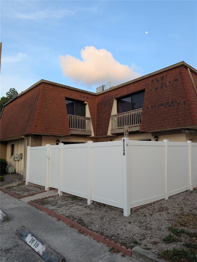8114 Oak Trace Way Unit D, Tampa, FL 33634 - view of home's exterior with mansard roof and a shingled roof