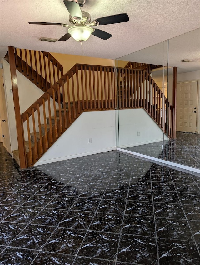 8114 Oak Trace Way Unit D, Tampa, FL 33634 - unfurnished living room with a ceiling fan, stairs, and a textured ceiling