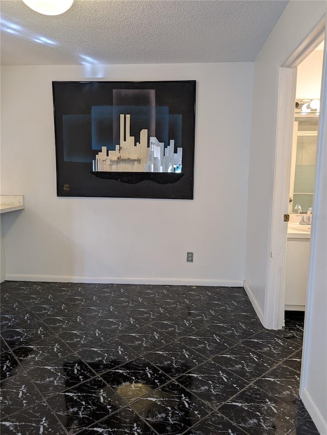 8114 Oak Trace Way Unit D, Tampa, FL 33634 - empty room with marble look tiles, baseboards, and a textured ceiling