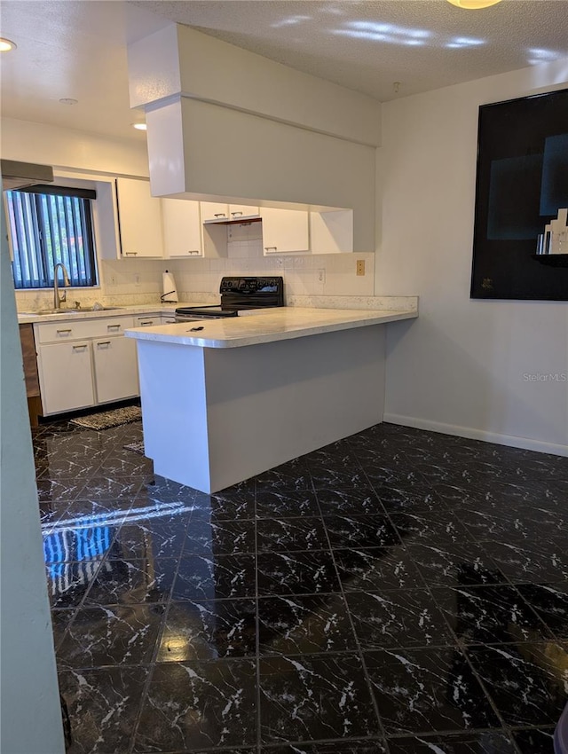 8114 Oak Trace Way Unit D, Tampa, FL 33634 - kitchen with black electric range, a sink, a peninsula, white cabinets, and light countertops