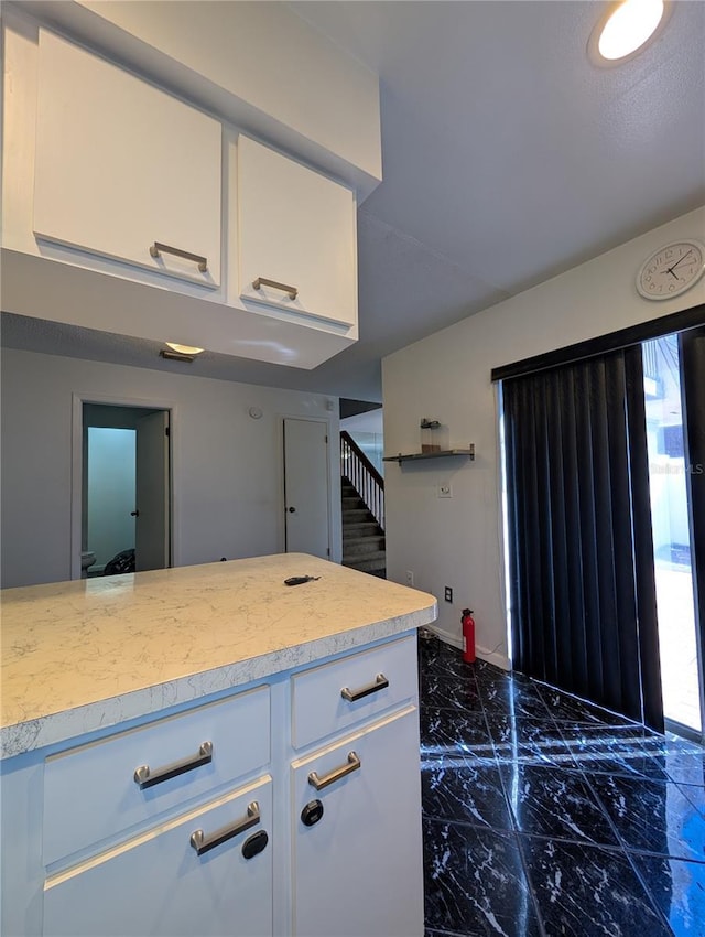 8114 Oak Trace Way Unit D, Tampa, FL 33634 - kitchen with light countertops, dark marble finish flooring, white cabinetry, and baseboards