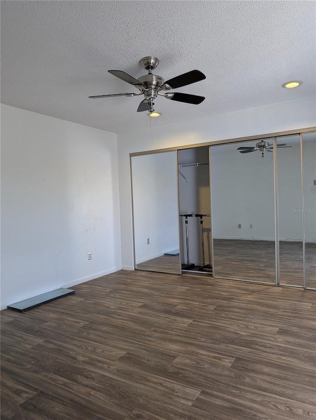 8114 Oak Trace Way Unit D, Tampa, FL 33634 - unfurnished bedroom featuring dark wood-type flooring, a textured ceiling, baseboards, and a ceiling fan