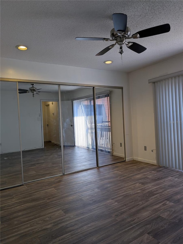 8114 Oak Trace Way Unit D, Tampa, FL 33634 - unfurnished bedroom featuring wood finished floors, baseboards, a textured ceiling, and ceiling fan